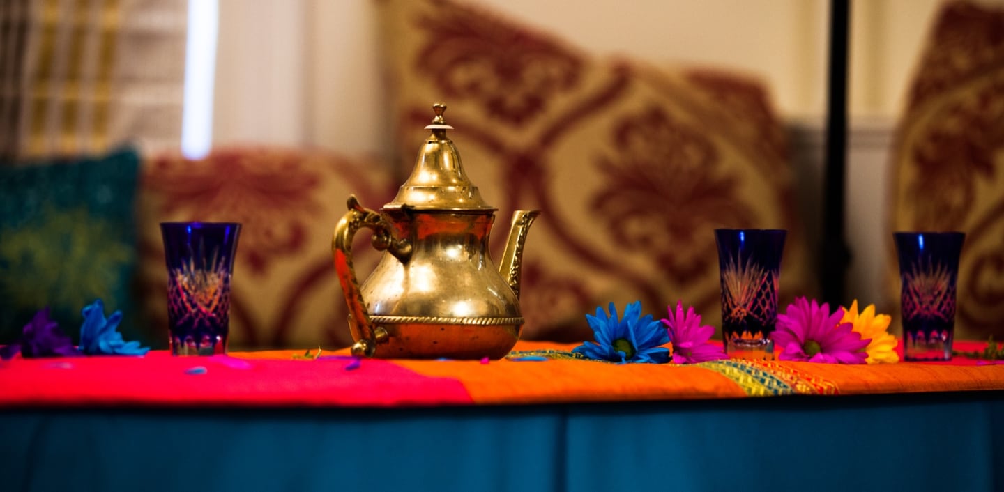 Colorful ceremonial table with a brass pot and blue glasses